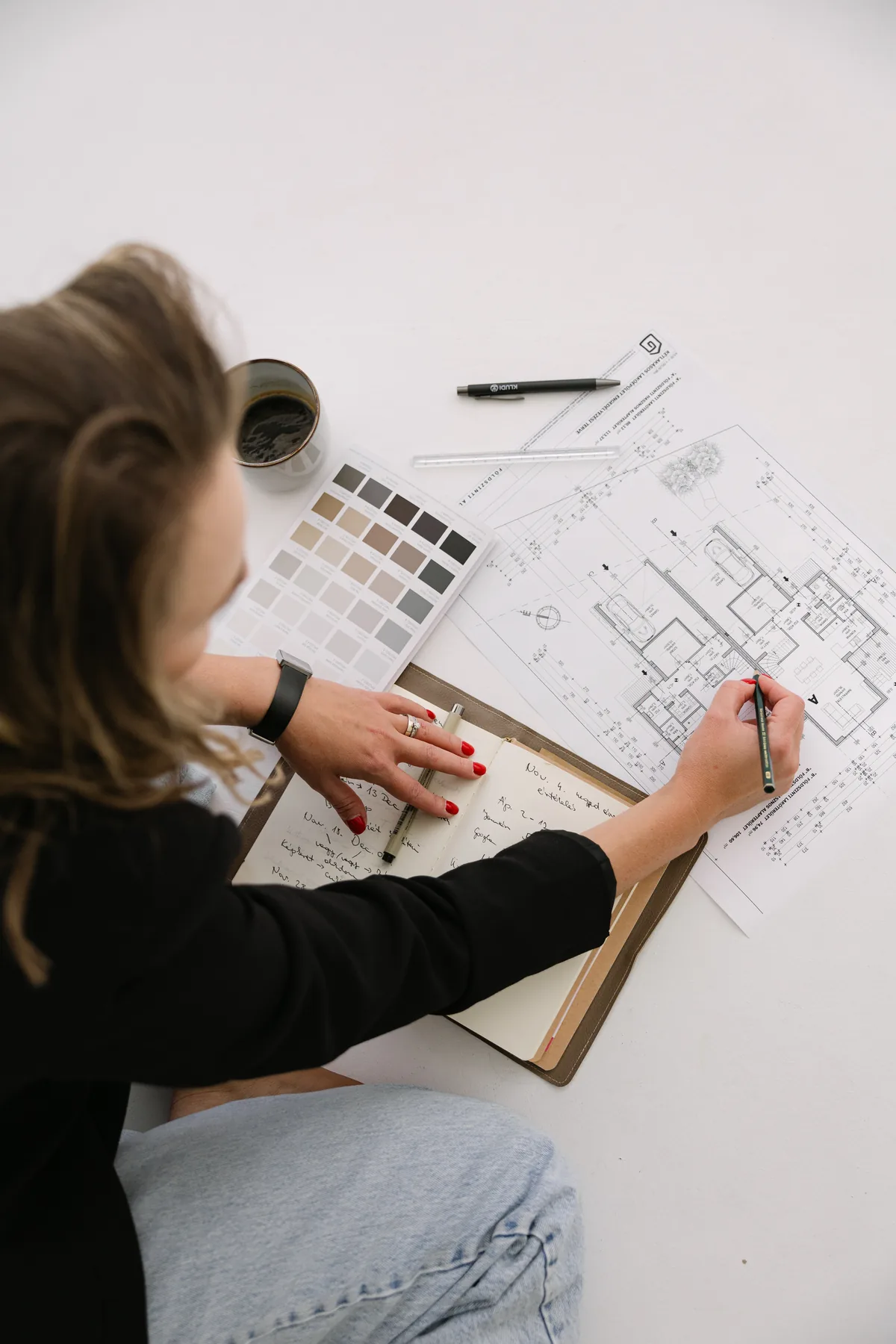 Adrienn Beck planning over floor plans and a color palette